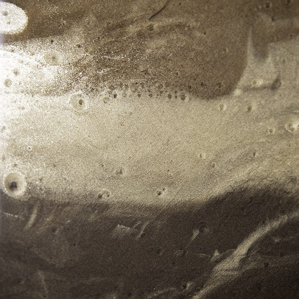 Closeup detail of the glossy finish on Luxury abstract gold resin wall art with a metallic finish on a dark bronze background, with gold highlights. handmade contemporary wall art by Elysian Bespoke