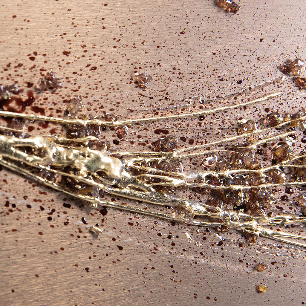 closeup of bronze metal wall art with gold highlights