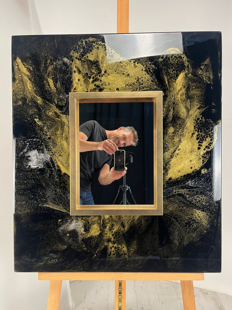 Handmade abstract resin wall mirror with black and gold metallic textures, luxury contemporary decorative mirror featuring a brushed gold frame for modern interior design.