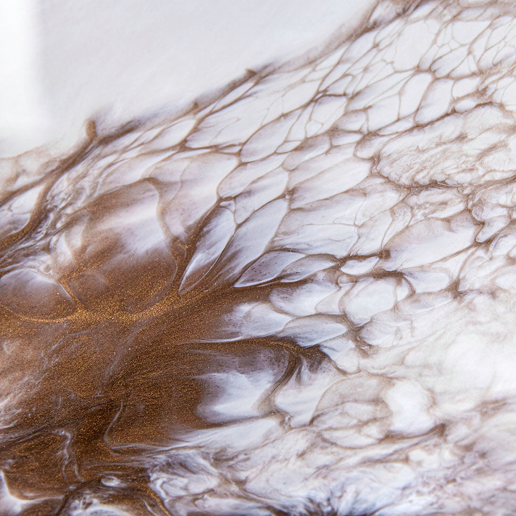 Closeup of bronze and cream liquid art on metal wall art. Hand made in UK.