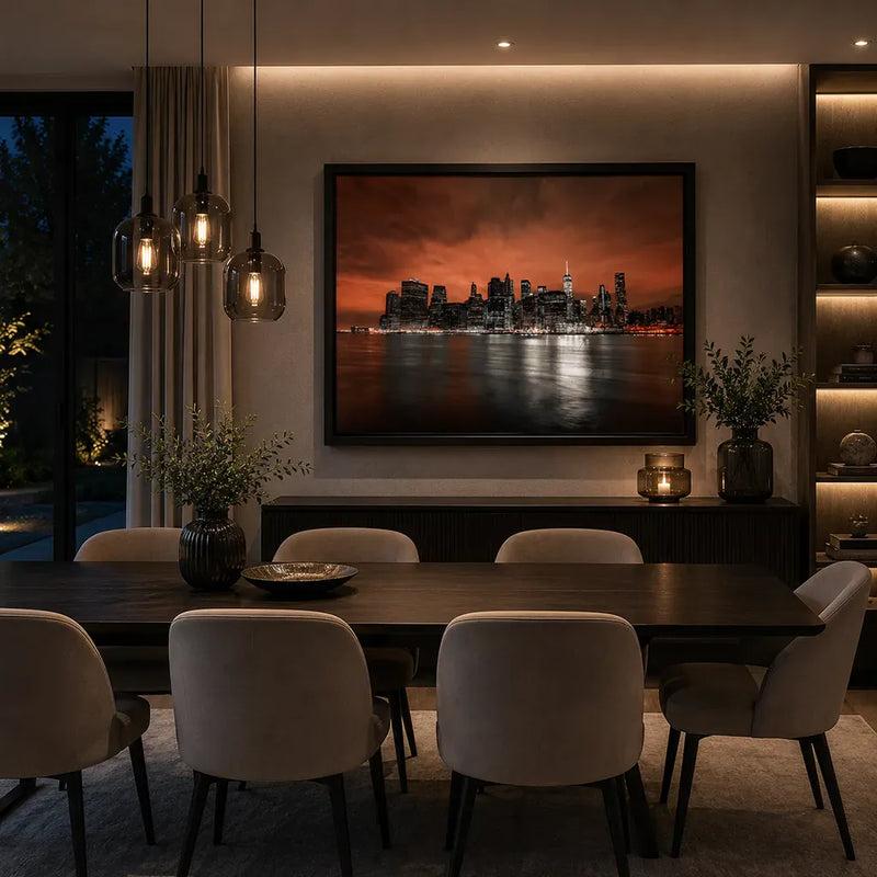 Modern Manhattan skyline wall art in a modern dining room. colours black, white and Rose tones, panoramic New York City artwork with dramatic sunset sky and East River reflections in a luxury black frame.