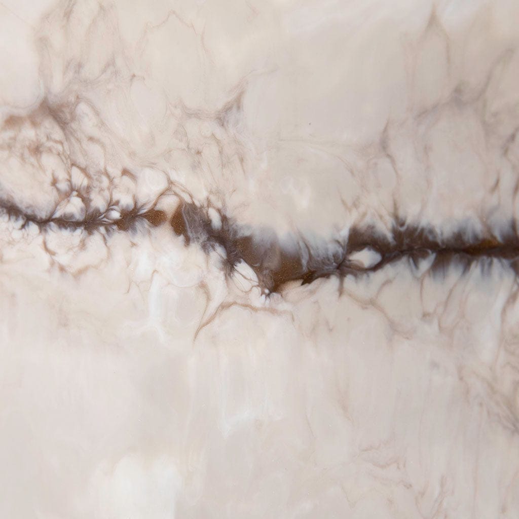 Closeup of resin metal wall art in creams and bronze.