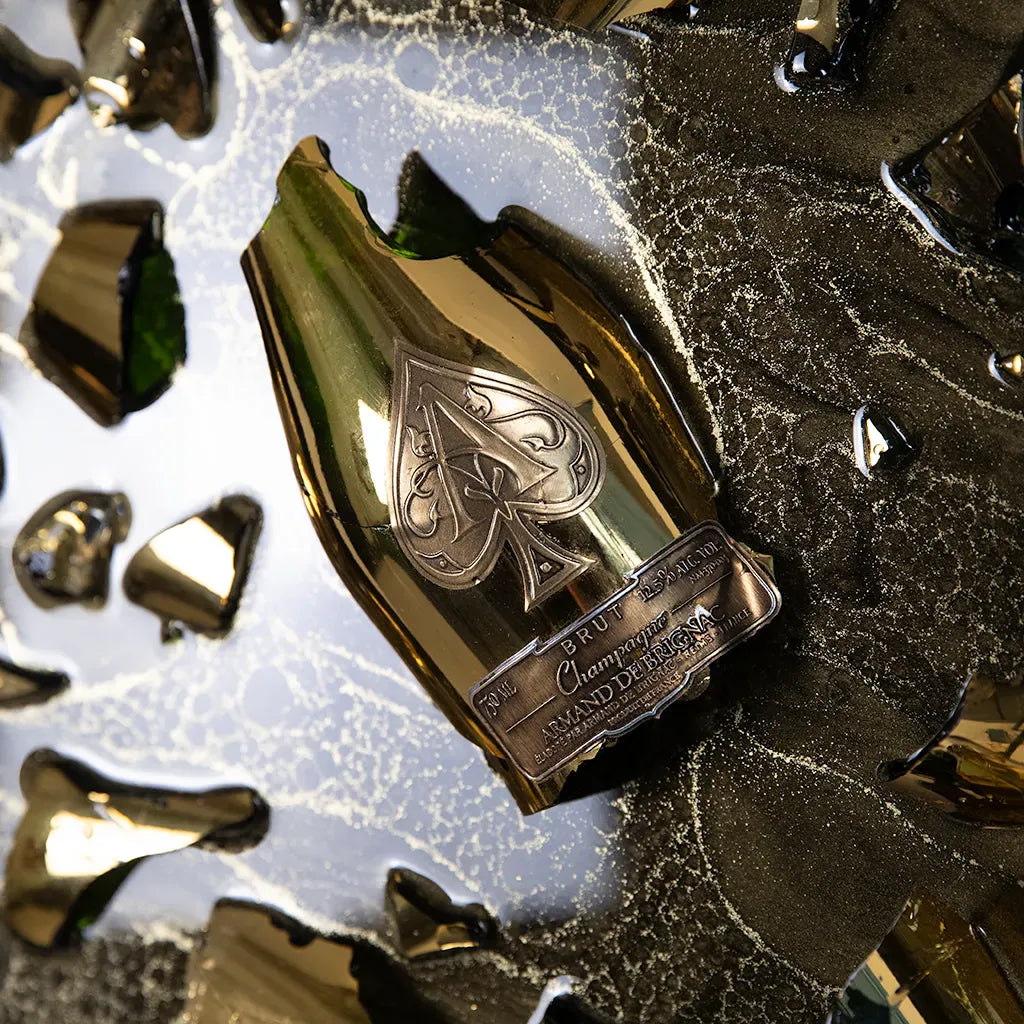 close up 0f One-of-a-kind Armand de Brignac gold bottle and fragments set in textured metallic resin, handmade and framed by British artist Paul Marshall