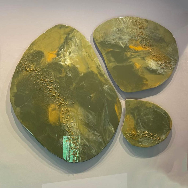 set of 3 pebble shaped custom resin wall art. abstract design in greens with an accent of white and gold. gold and white glass crystals detailing. Hand made by paul marshall at elysian bespoke.