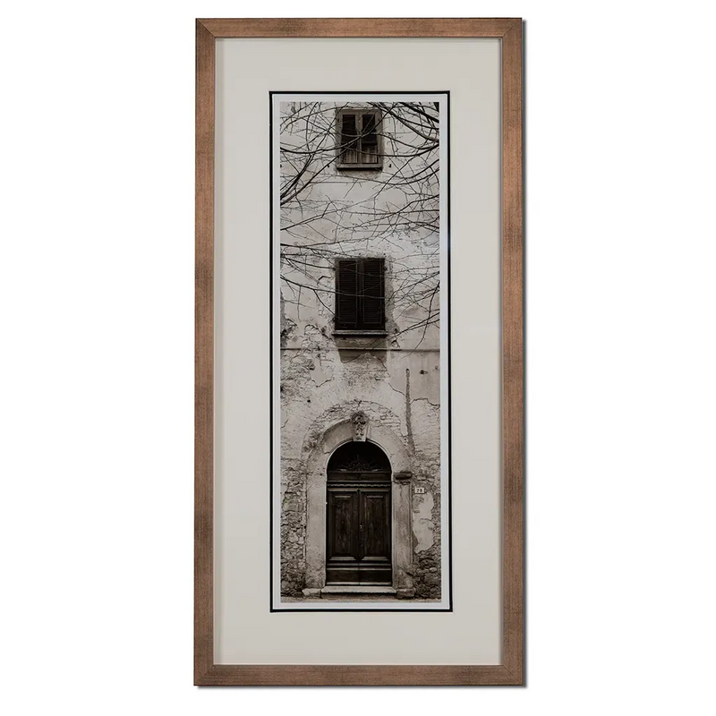 Bronze framed Italian stone archway wall art featuring a historic rustic wooden doorway in monochrome architectural photography. Handmade luxury framed artwork by Elysian Bespoke for contemporary home