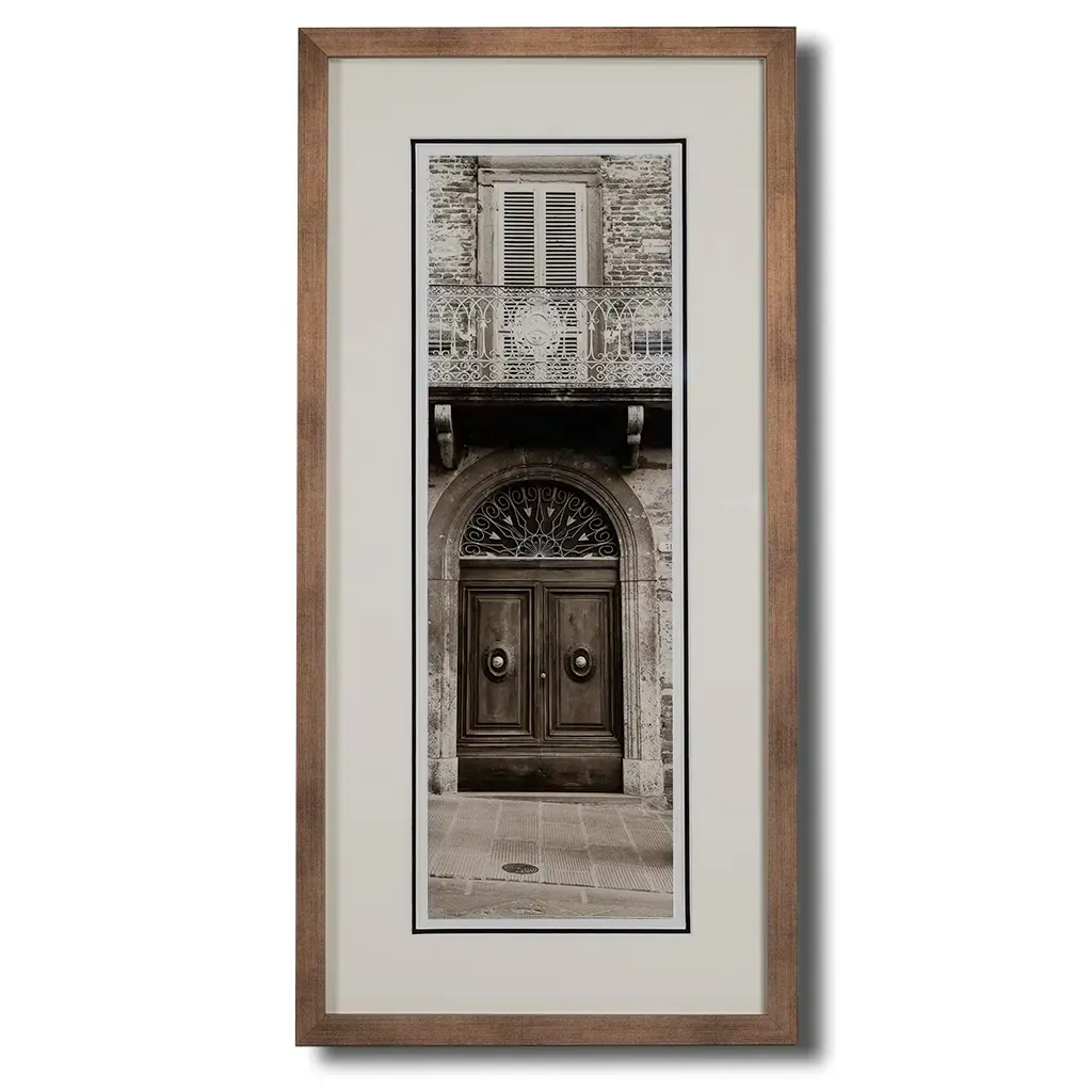 Bronze framed Italian stone archway wall art featuring a historic rustic wooden doorway in monochrome architectural photography. Handmade luxury framed artwork by Elysian Bespoke for contemporary home interiors.