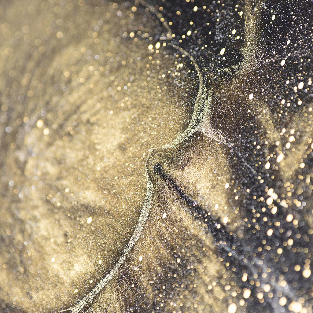 Close up of resin art work, gold and black hand thrown metal wall art 