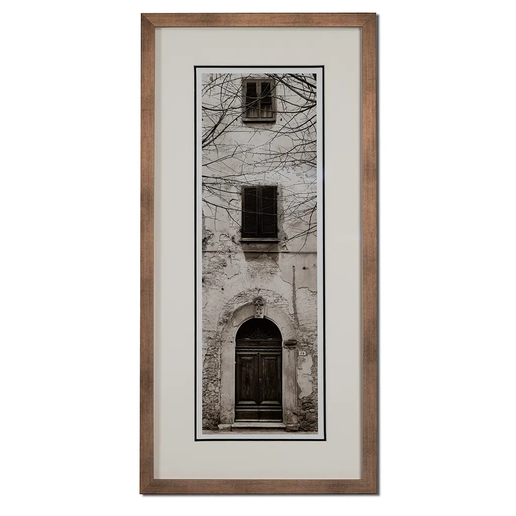 Bronze framed Italian stone archway wall art featuring a historic rustic wooden doorway in monochrome architectural photography. Handmade luxury framed artwork by Elysian Bespoke for contemporary home 