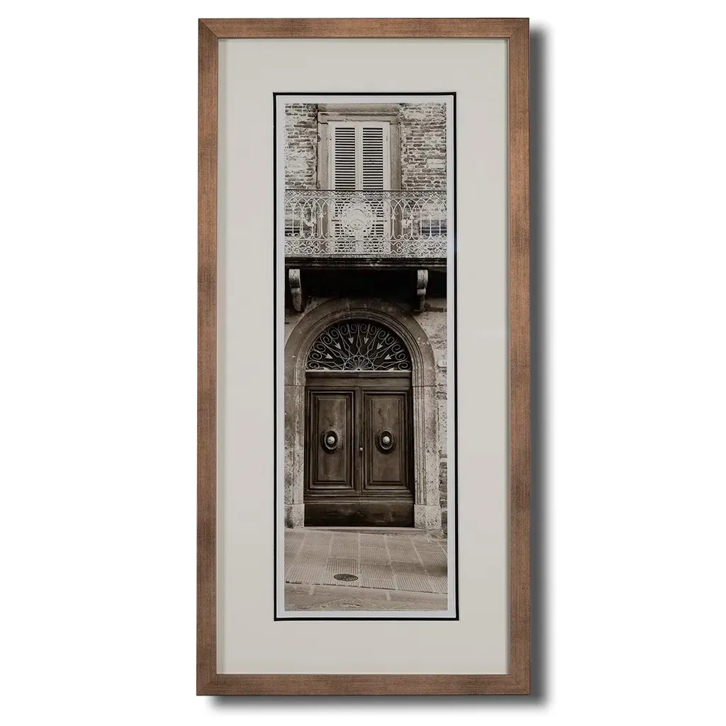 Bronze framed Italian stone archway wall art featuring a historic rustic wooden doorway in monochrome architectural photography. Handmade luxury framed artwork by Elysian Bespoke for contemporary home interiors.