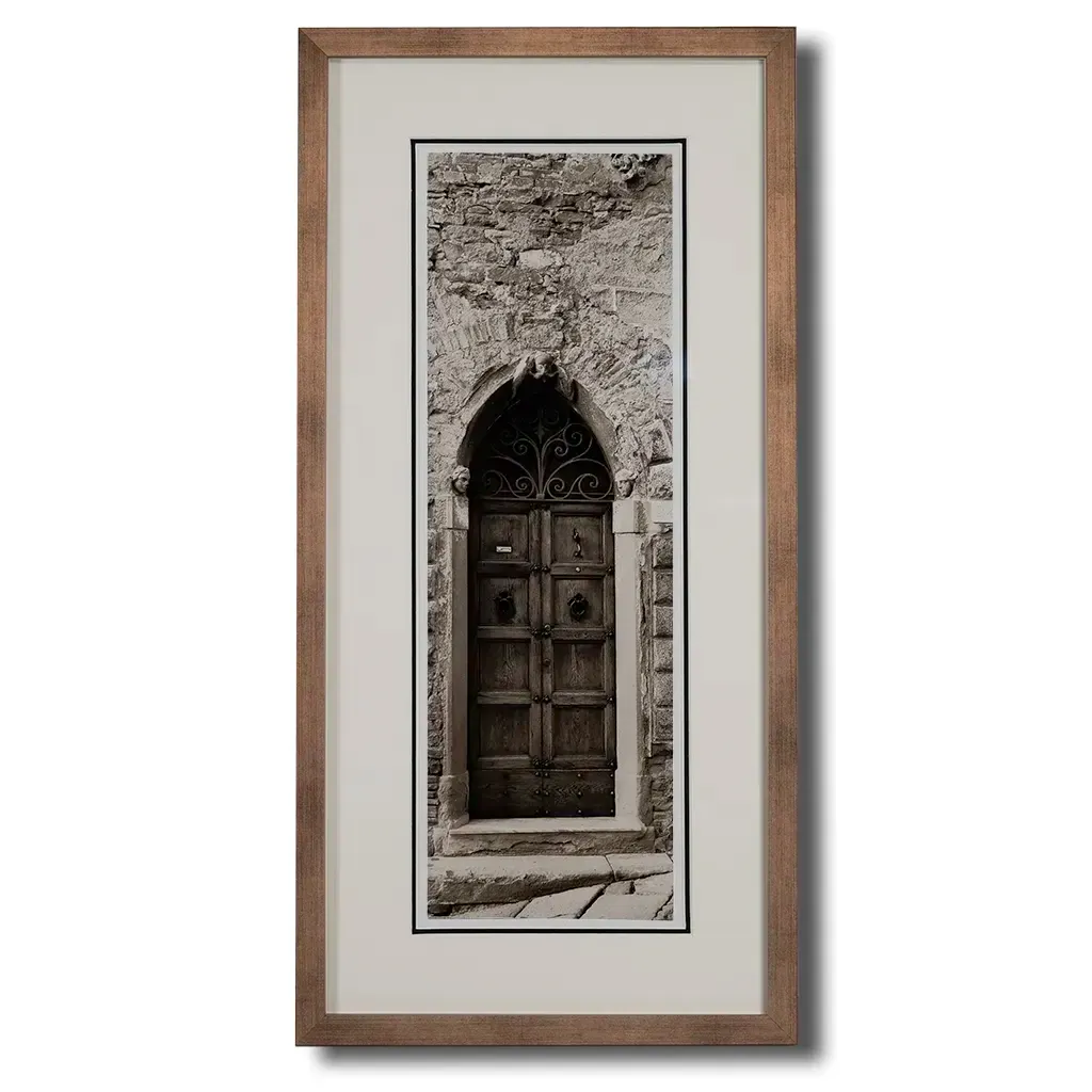 Bronze framed Italian stone archway wall art featuring a historic rustic wooden doorway in monochrome architectural photography. Handmade luxury framed artwork by Elysian Bespoke for contemporary home 